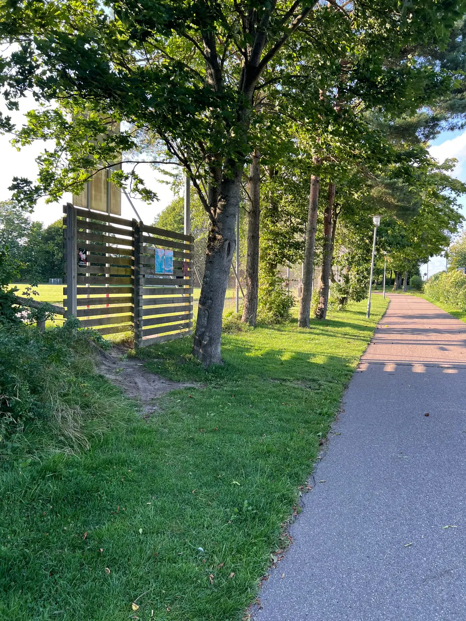 Indgangen gennem hegnet til banen ved Hasle Skole.