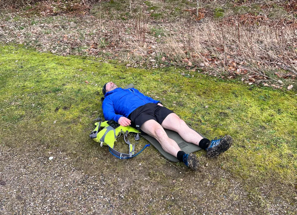 Jeppe Welling Hansen resting on a sleeping mat after a low-blood-sugar episode during an ultramarathon.